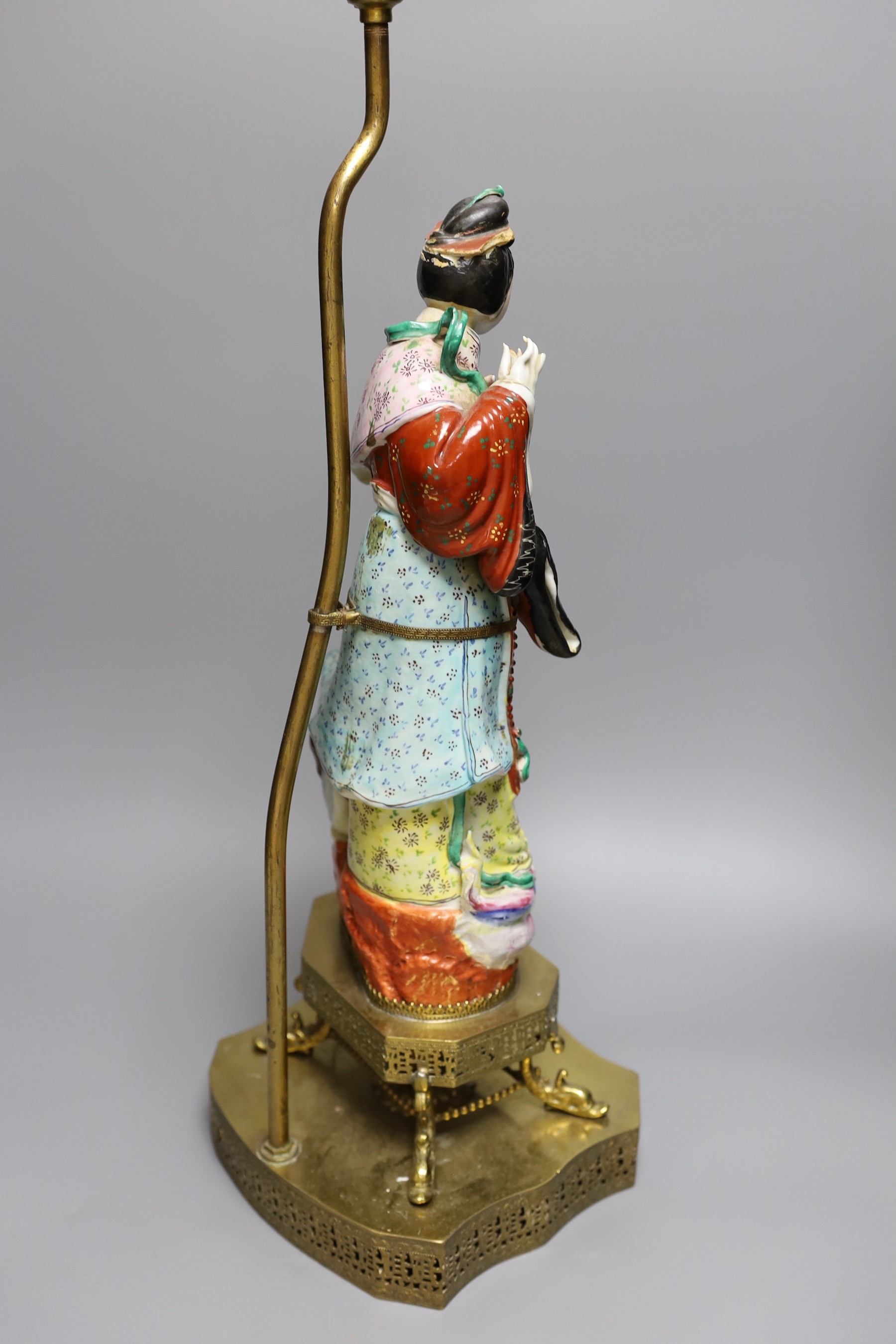 An early 20th century Chinese brass mounted porcelain figural lamp, total height 59cm